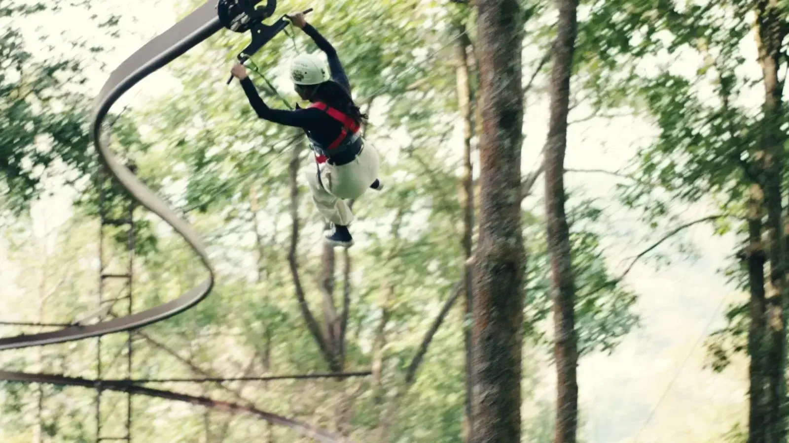 Roller coaster zipline track curving through standing forest at Ban Jungle — Nepal's longest RCZ
