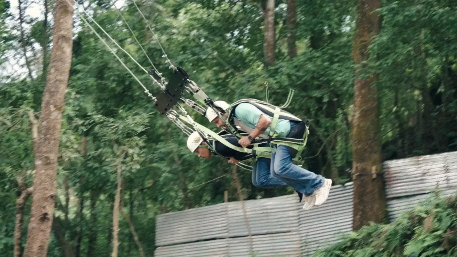 Rider on the tree-mounted roller coaster zipline track at Ban Jungle, Kathmandu