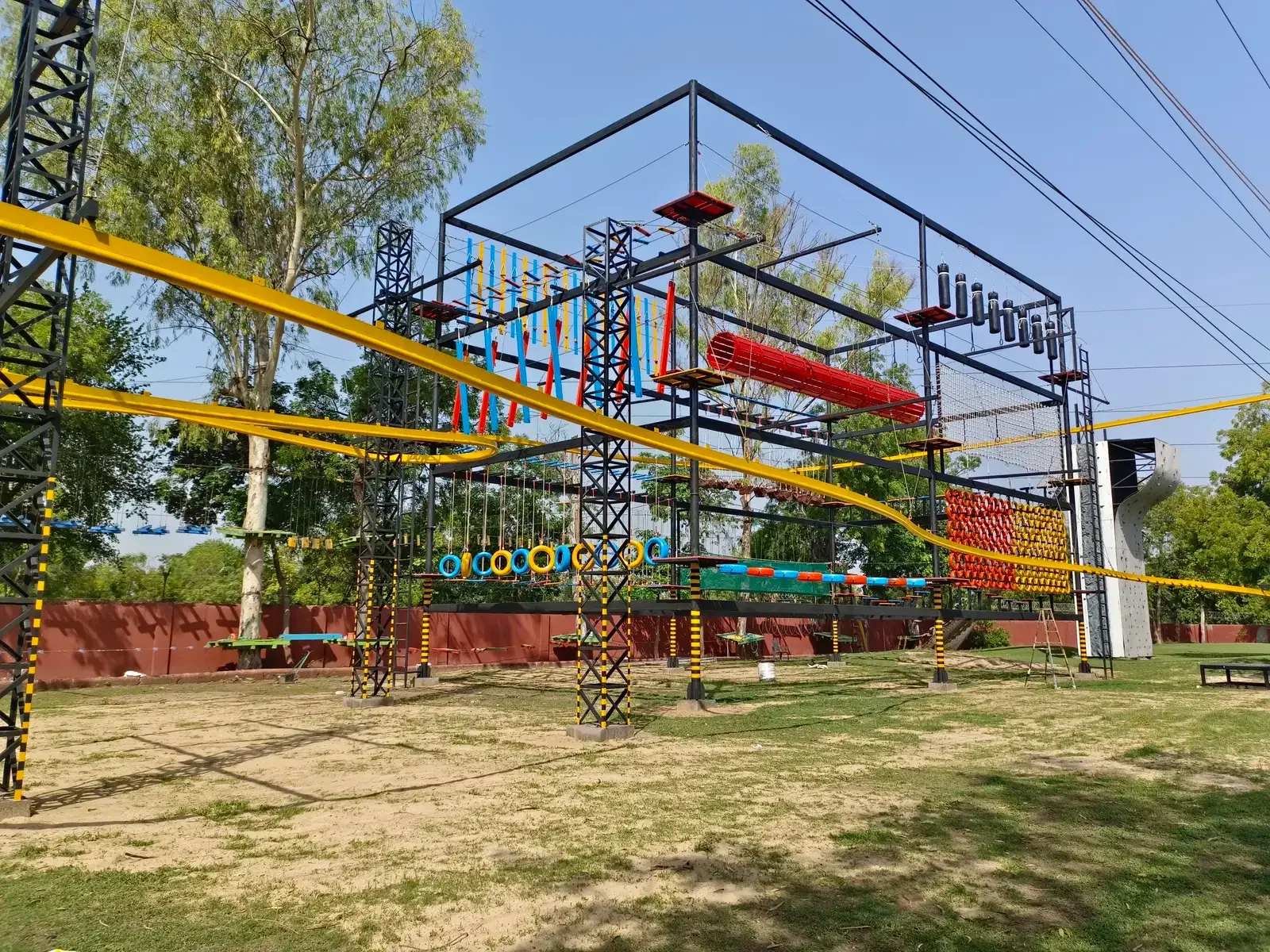 Ropes-course structure with the yellow roller coaster zipline track at Roadies Rostel, Ahmedabad