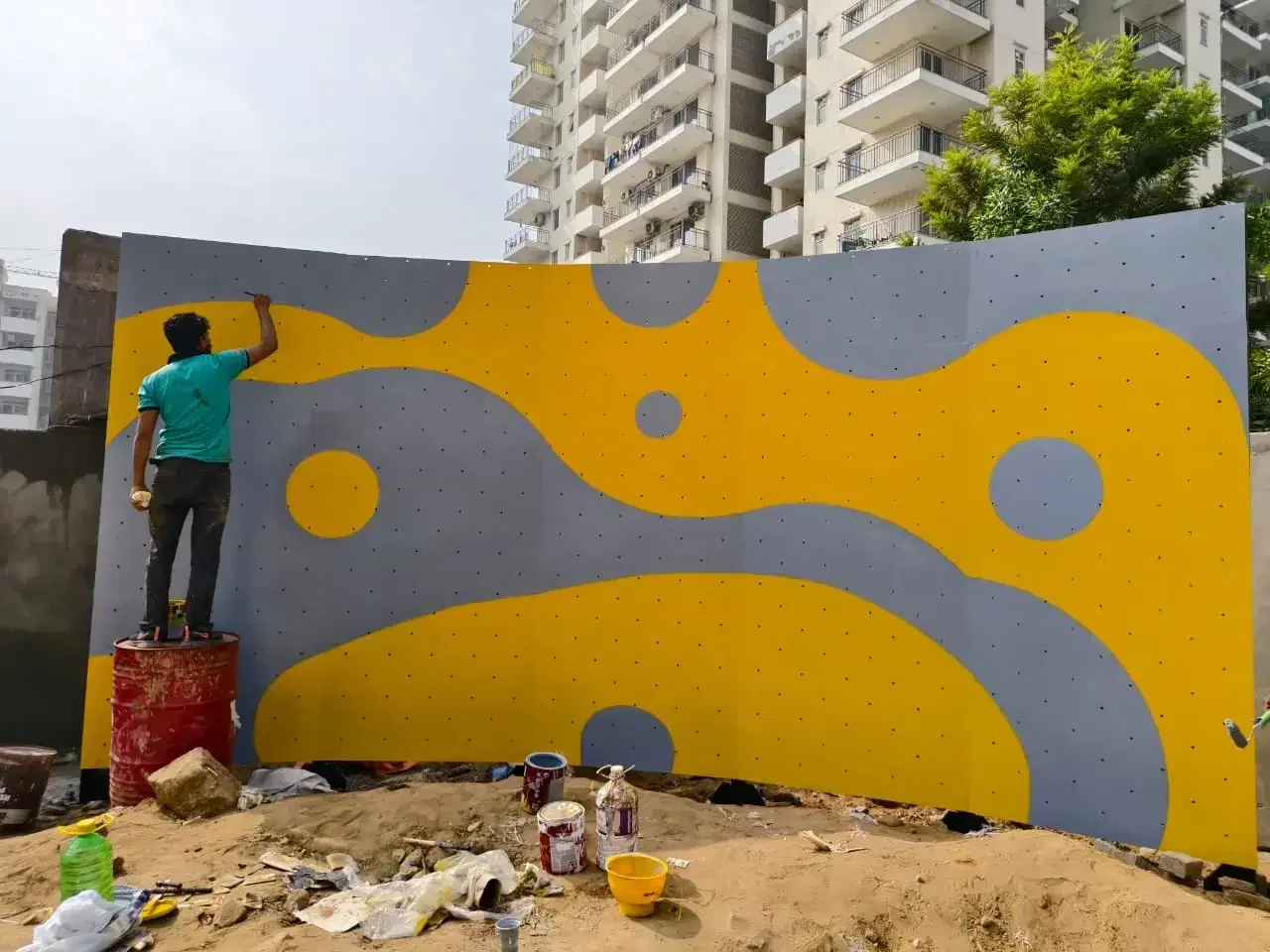 Artists hand-painting the Mapsko bouldering wall artwork