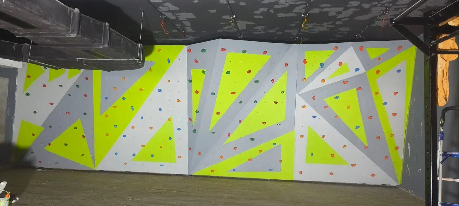Traverse bouldering wall with neon geometric panels at Fitkits Gym, Chennai
