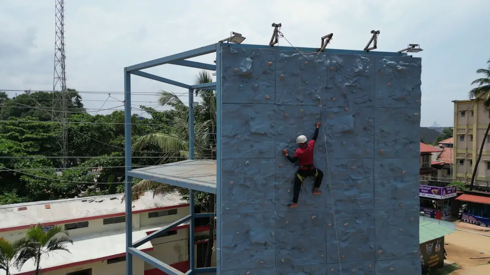 Climber high on the tower wall with Panambur Beach below