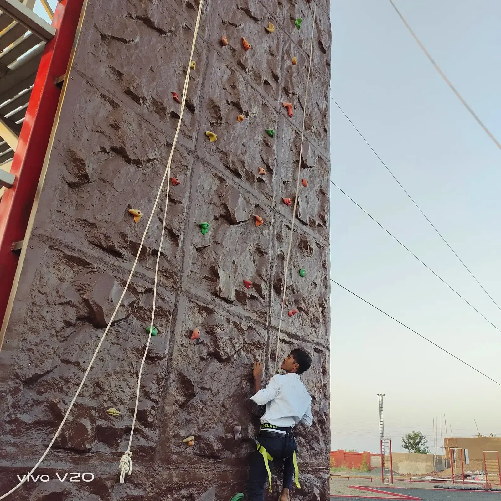 Climber ascending the rock-finish wall at Prabhu Farms, Rajkot
