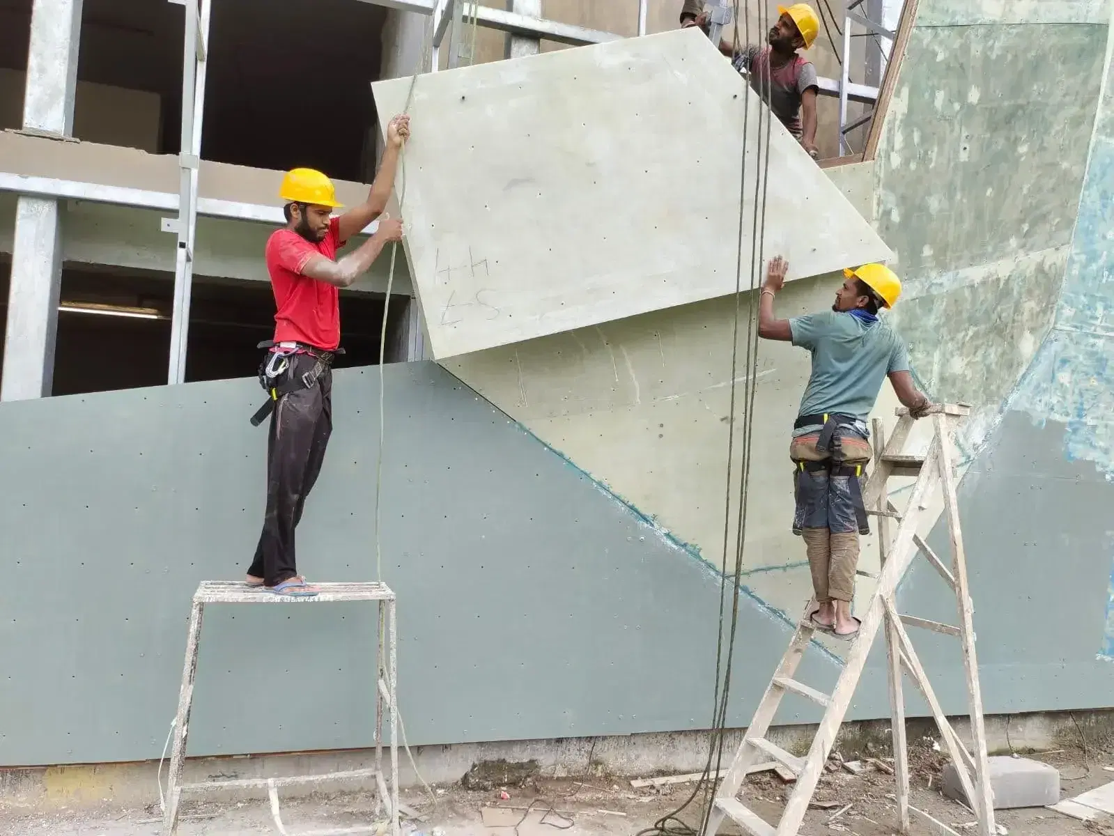 Crew installing geometric climbing panels at Ambuja Neotia