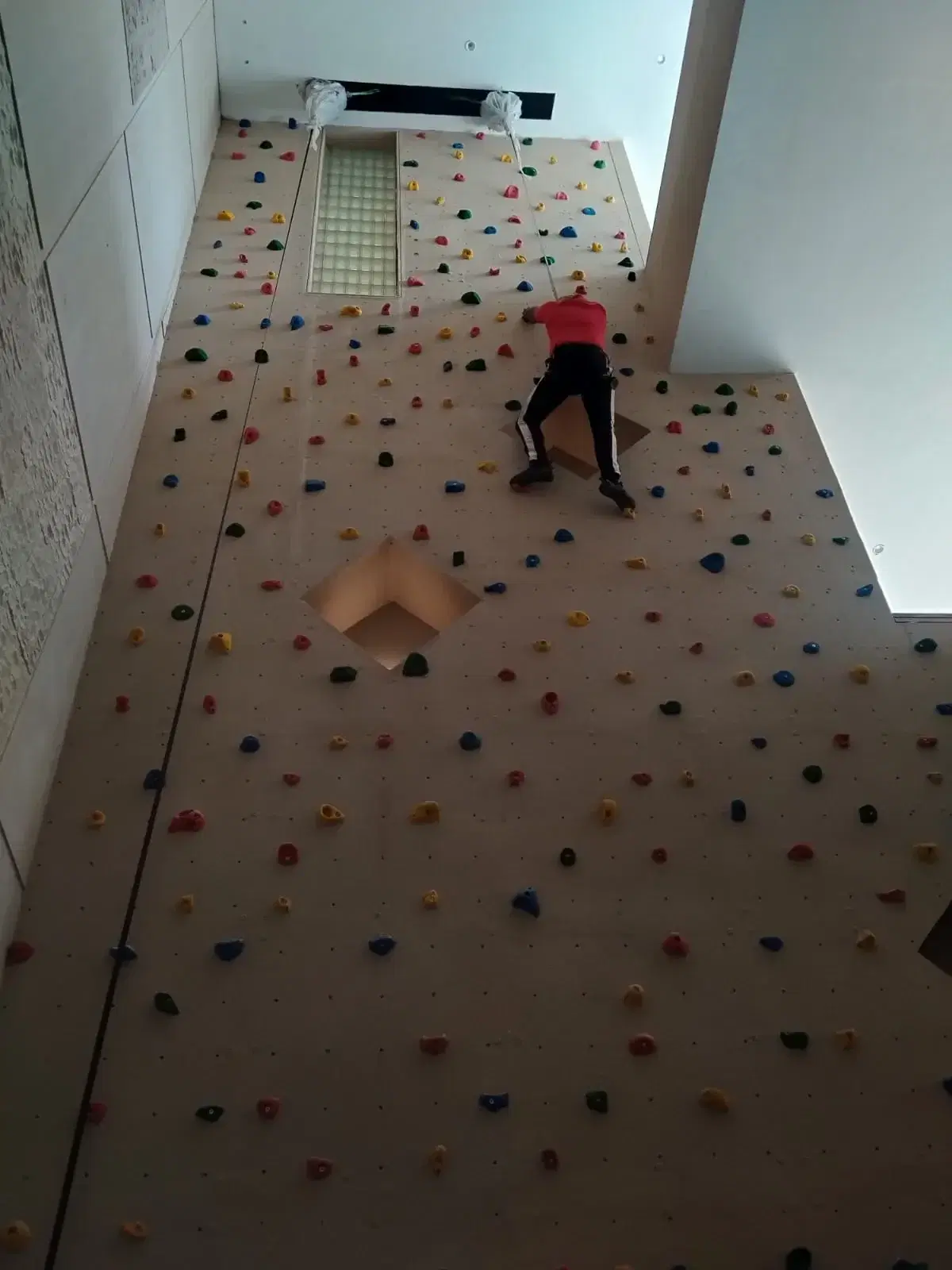 Climber scaling the OutisOut designer wall inside the residence