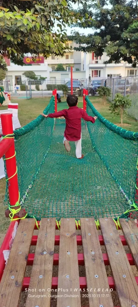 Child crossing the net bridge on the Swadhyay School obstacle course
