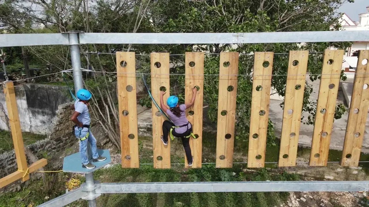 Plank wall crossing on the GI ropes course at Arya Kanya school