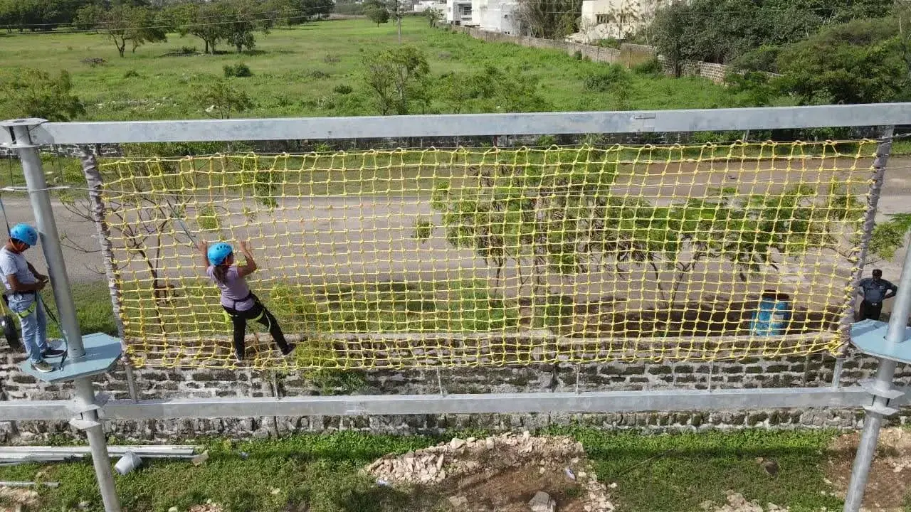 Student traversing the net section of the ropes course at Arya Kanya Public School, Porbandar