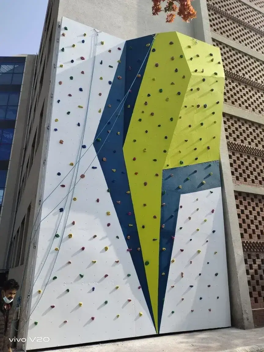 Geometric climbing wall in lime and blue at Orchids School, Gurugram