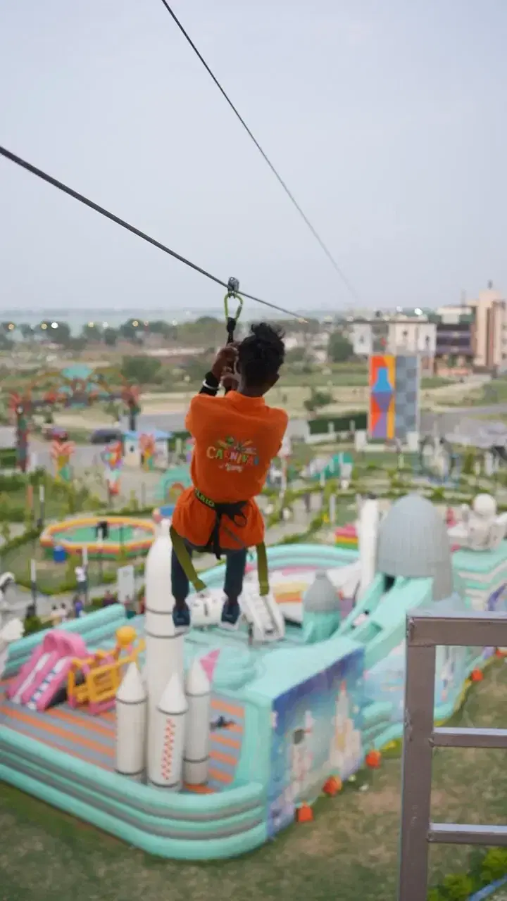Zipline rider passing over the inflatable park at JSR Park