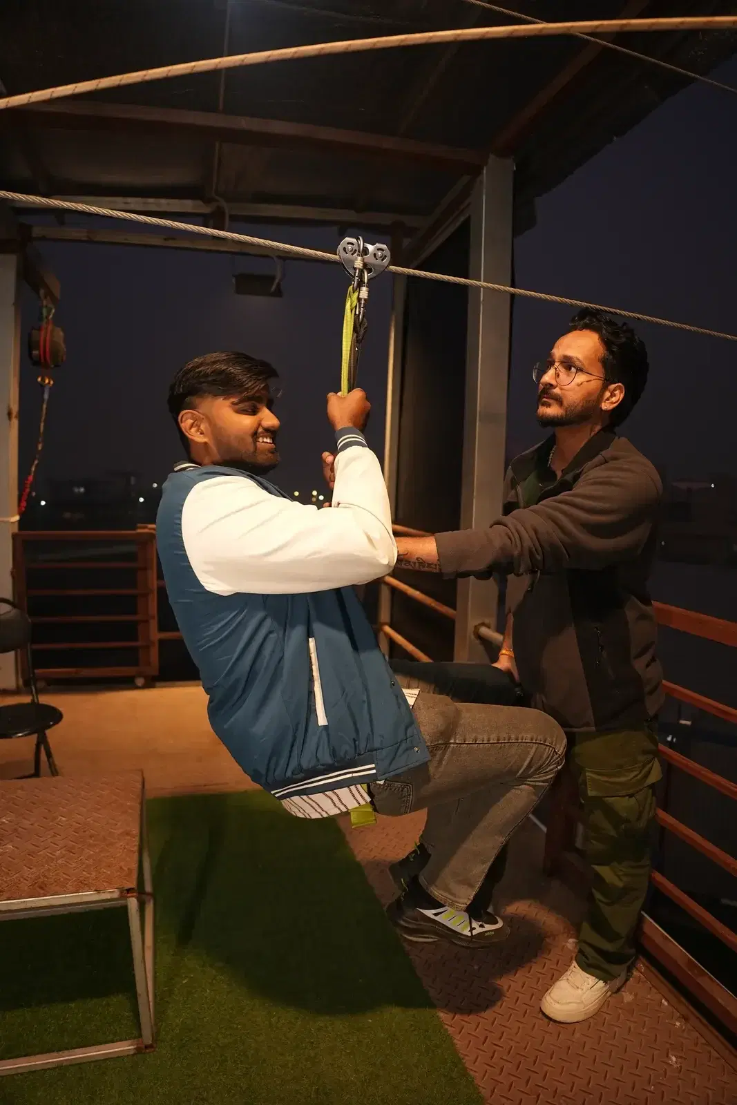Operator clipping a rider to the zipline trolley at JSR Park