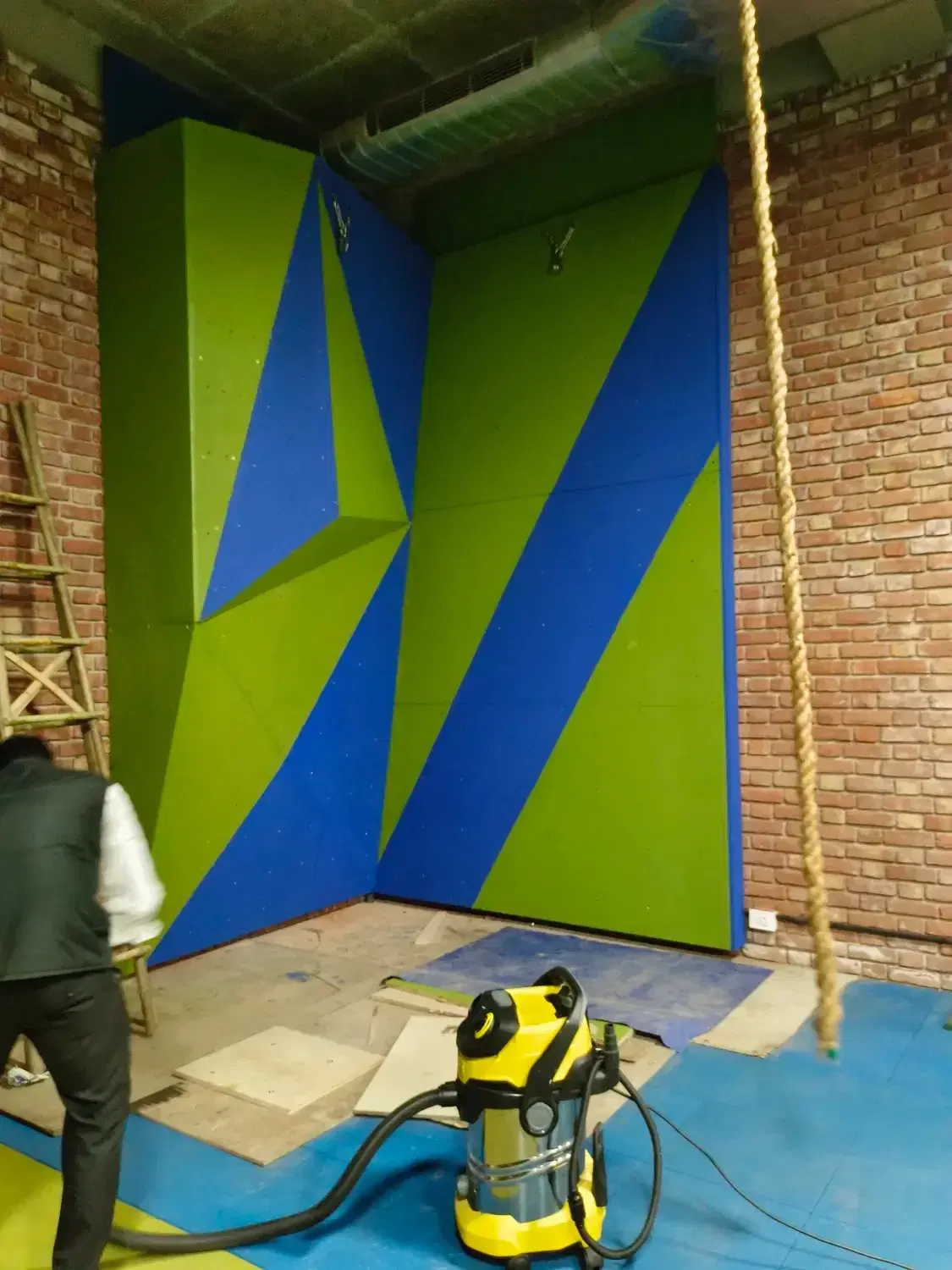 Climber on the geometric face of the DLF Farms bouldering wall