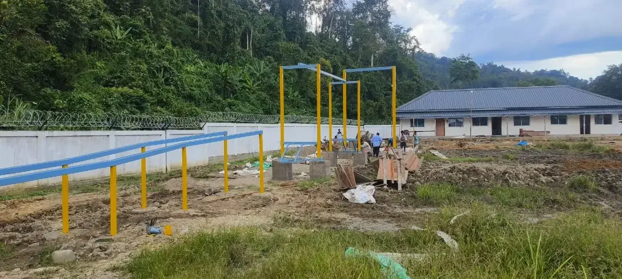 Obstacle course elements against the forested hills at Deomali