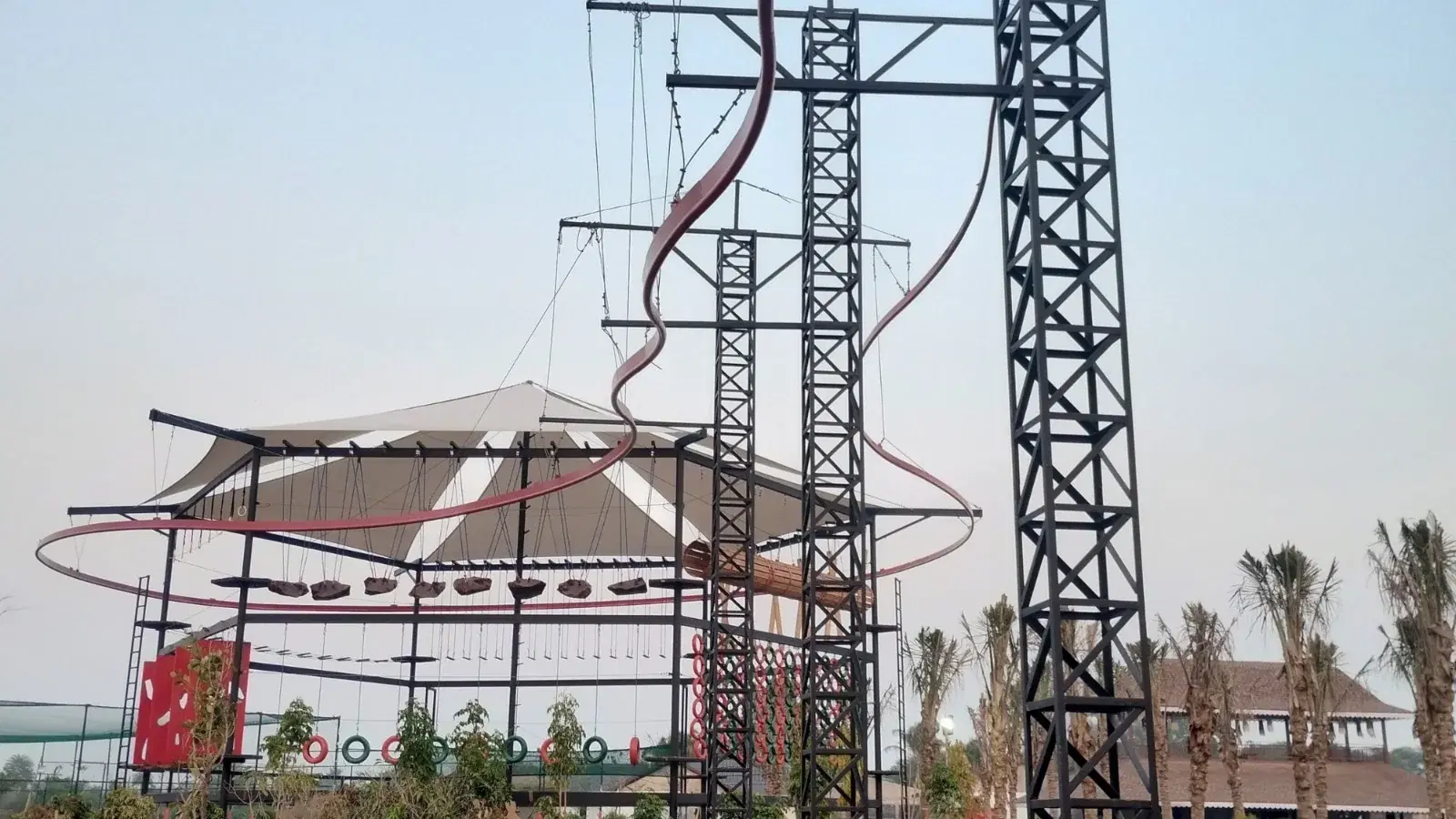 Integrated adventure structure at Maira Resort with roller coaster zipline track, ropes course and tensile canopy