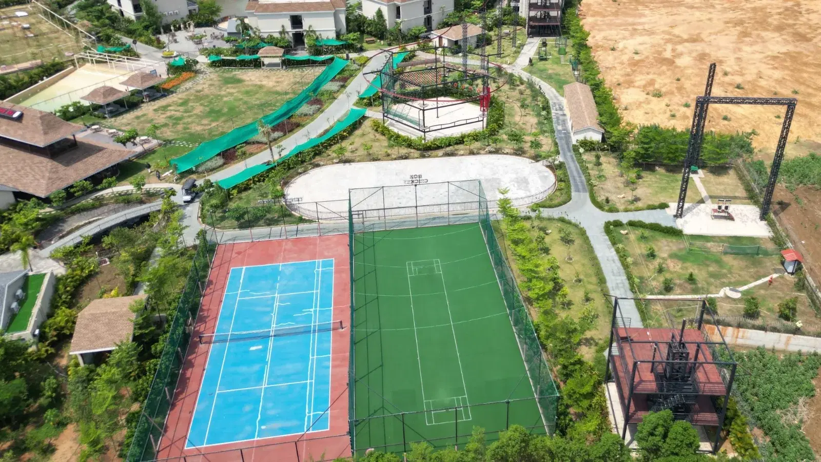 Aerial view of the Maira Resort adventure zone beside the sports courts, with giant swing and quick jump tower