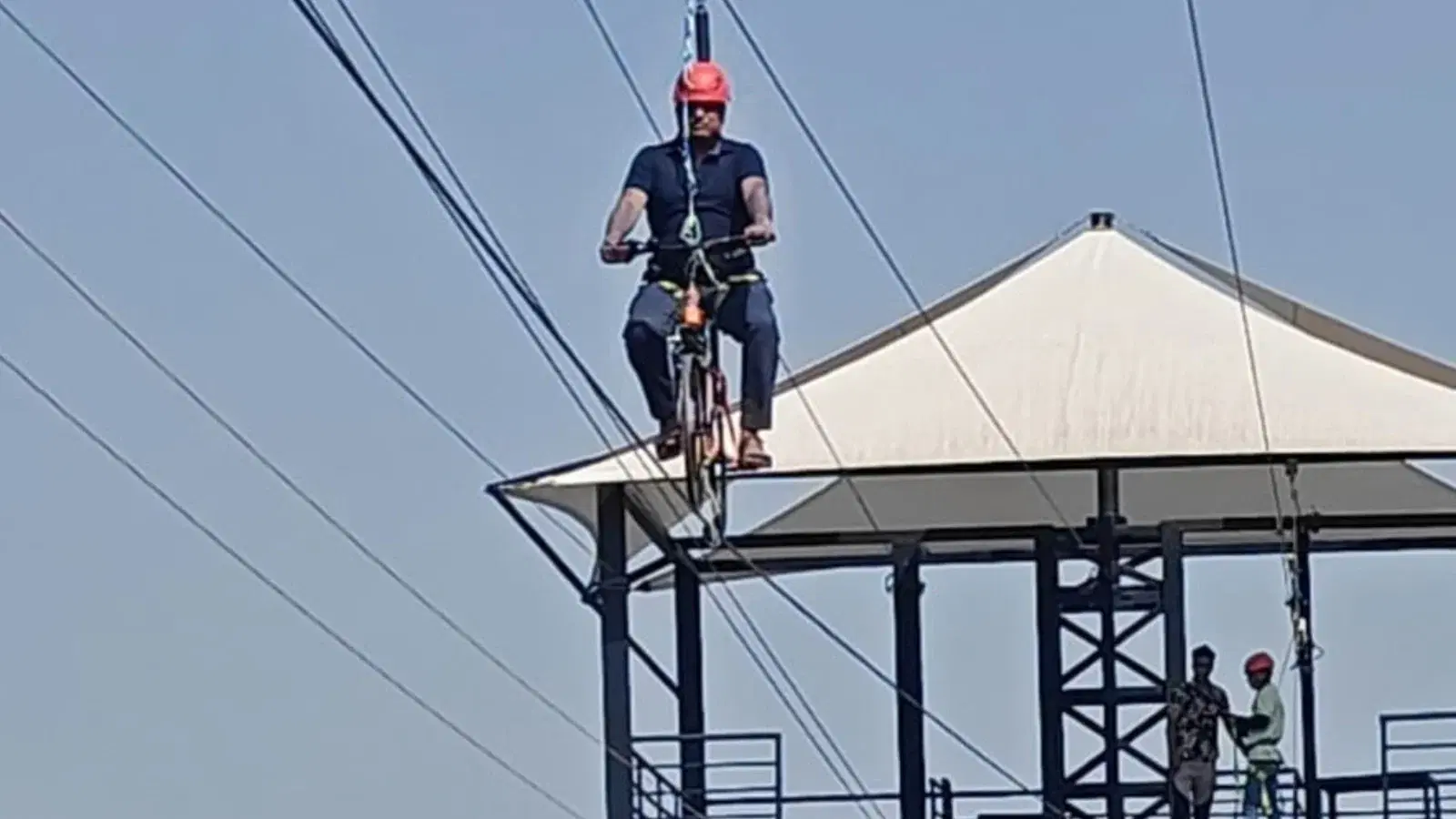Guest riding the sky cycle above a platform at Maira Resort adventure park